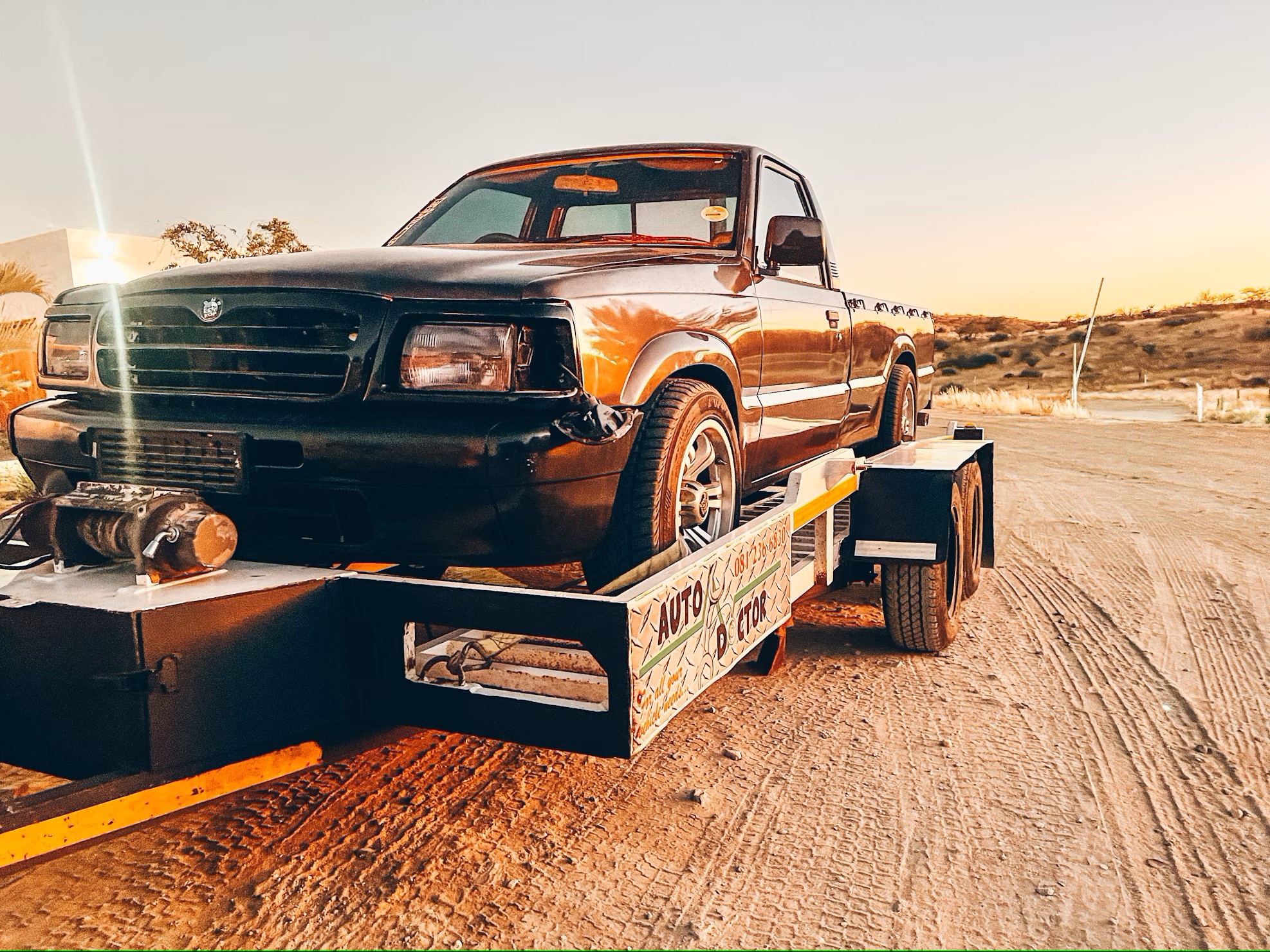 Small pickup truck on trailer showcasing aftermarket truck parts and towing accessories