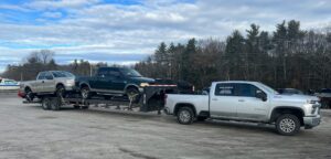 pickuptruck pulling trailer with two trucks