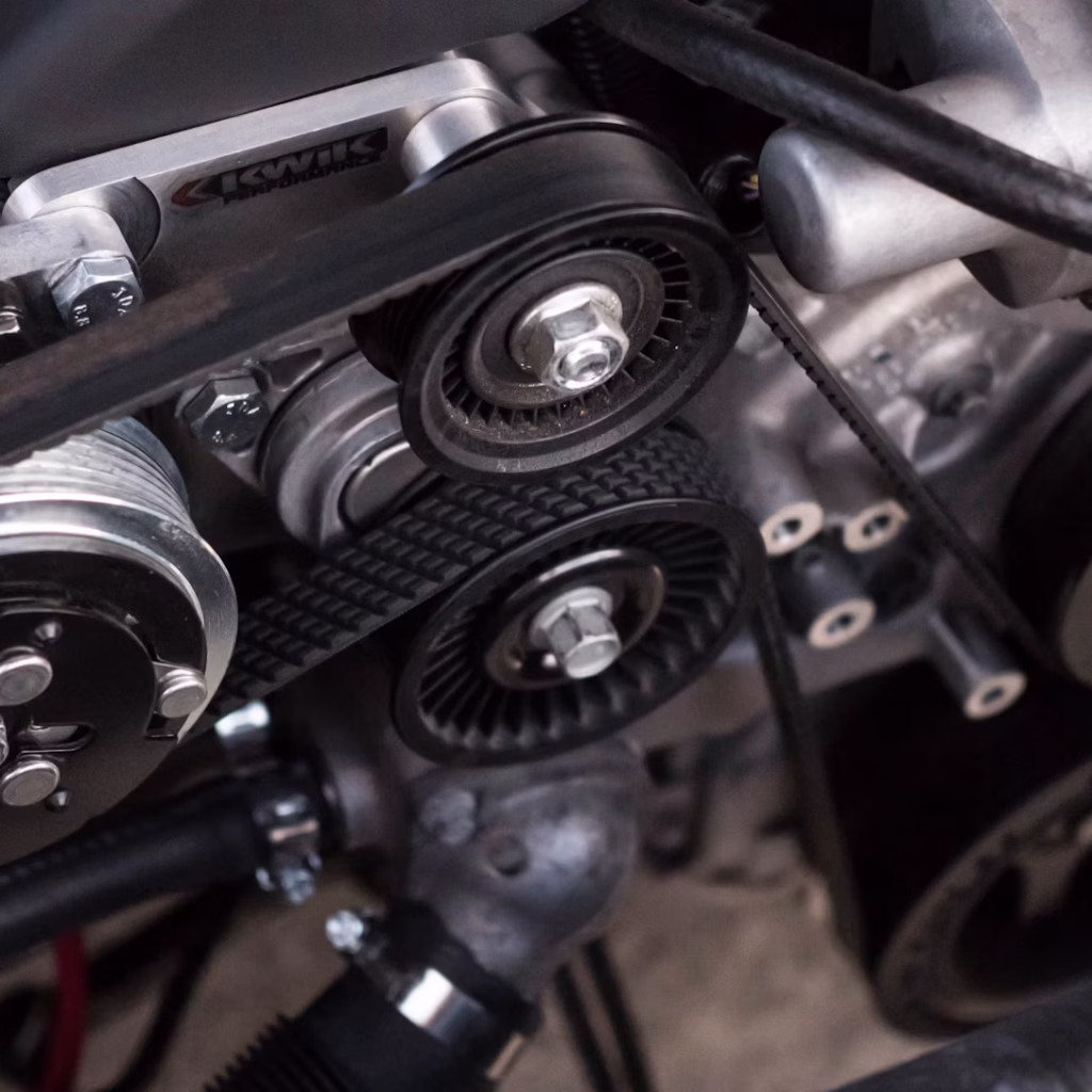 Close-up of automotive belts under the hood — expert emergency repair and maintenance at Alpha Transmission Houston to keep your vehicle running smoothly